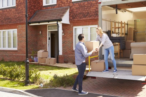 Workers loading furniture safely into a van with protective equipment